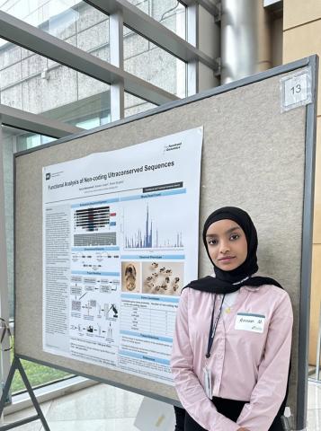Muhammed with scientific poster Muhammed stands in front of a scientific poster